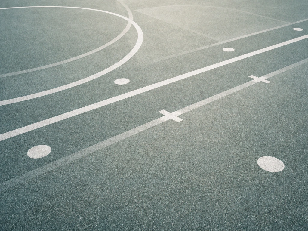 Gros plan sur des tracés de marquage au sol d’un terrain de sport : cercles, spots, lignes transversales et repères