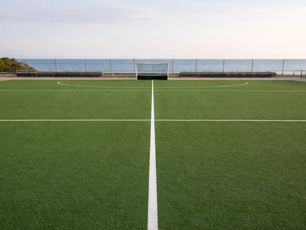 Terrain de hockey sur gazon synthétique homologué, avec marquages et buts, vu en perspective, sans personnes.
